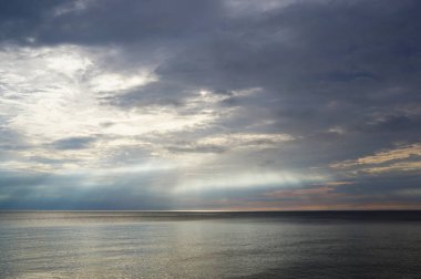 Güneş ışınları su yüzeyinde parlıyor.