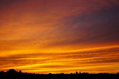Gün batımında parlak sarı ve turuncu bulutlar