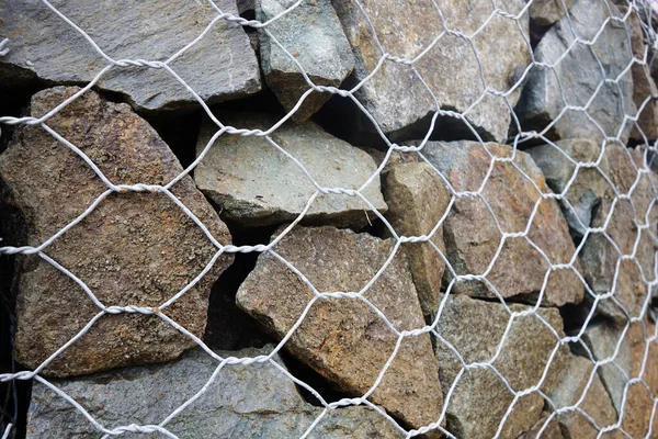 Dokulu arka plan, Gabion duvarlı kafes taşları yakın plan. Nesne inşa ediliyor.