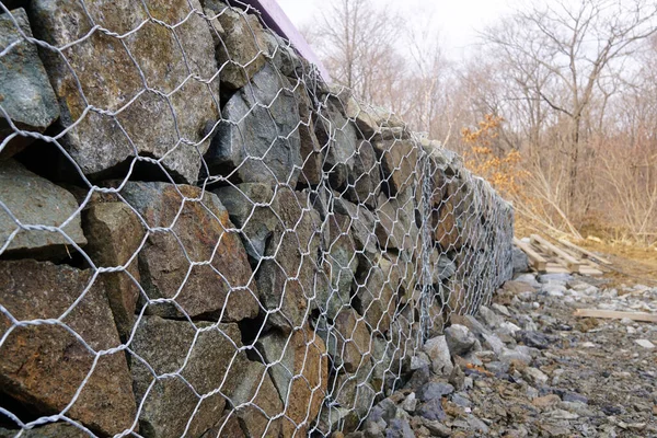 Dokulu arka plan, gabion duvarlı kafes taşları. Bina nesnesi, inşaat alanı.