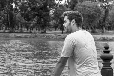 Adam kayıp bakışla bir nehir üzerinde bir köprü üzerinde