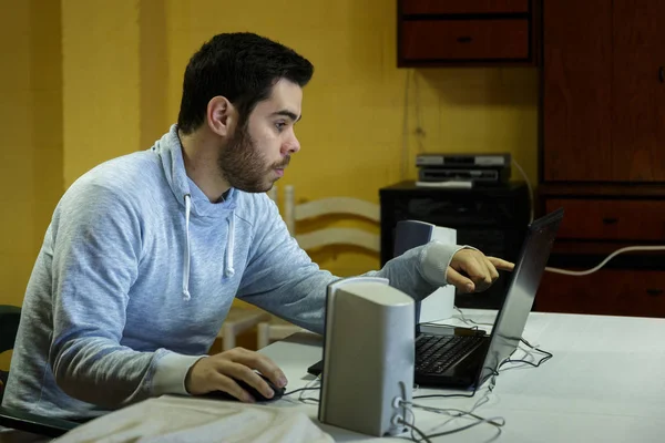 Genç adam cep telefonunu kullanarak tablet, dizüstü bilgisayar ve kulaklıklar