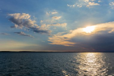 Denizde bulutlarla gün batımı