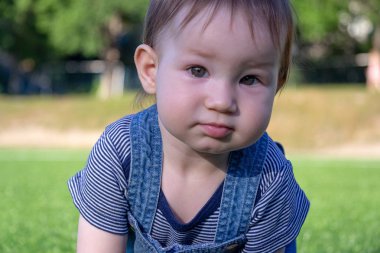 Bir yaz gününde çimenlerin üzerinde sürünerek çocuk