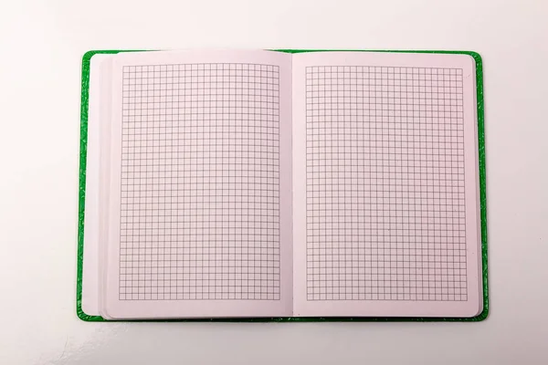 Um caderno aberto na mesa sobre um fundo branco — Fotografia de Stock
