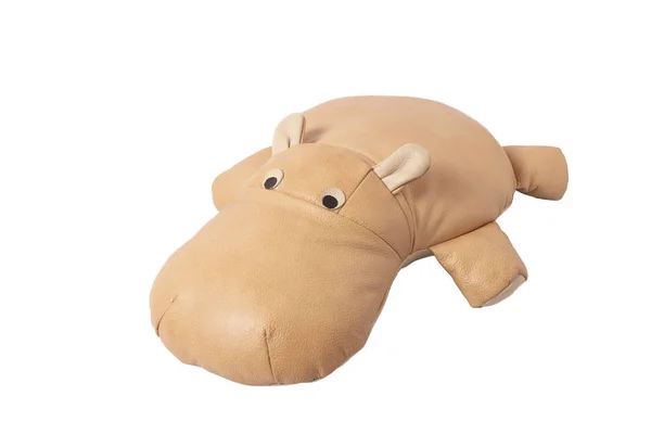 Beige toy leather hippo lies on a white background