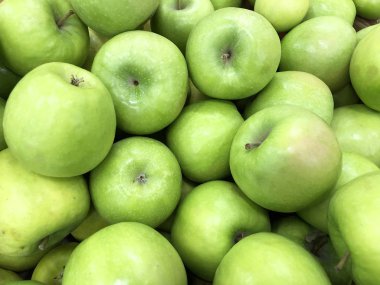 Birçok olgun yeşil elma bir sandıkta piyasada yalan
