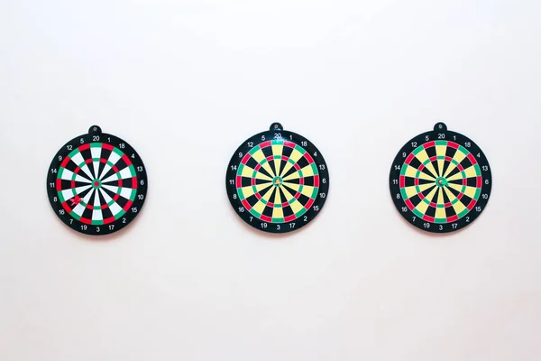 Gri bir duvara bir dart ile Üç Dart tahtası yakın