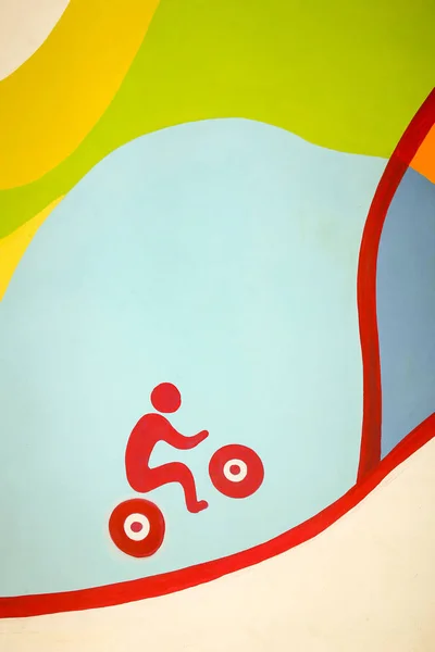 Renkli bir arka plan üzerinde tepeye kadar sürme kırmızı bir bisikletçi duvarında Kabataslak resim