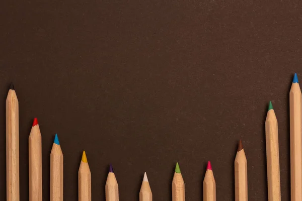 Renkli kalemler siyah bir arka plan üzerinde yatıyor