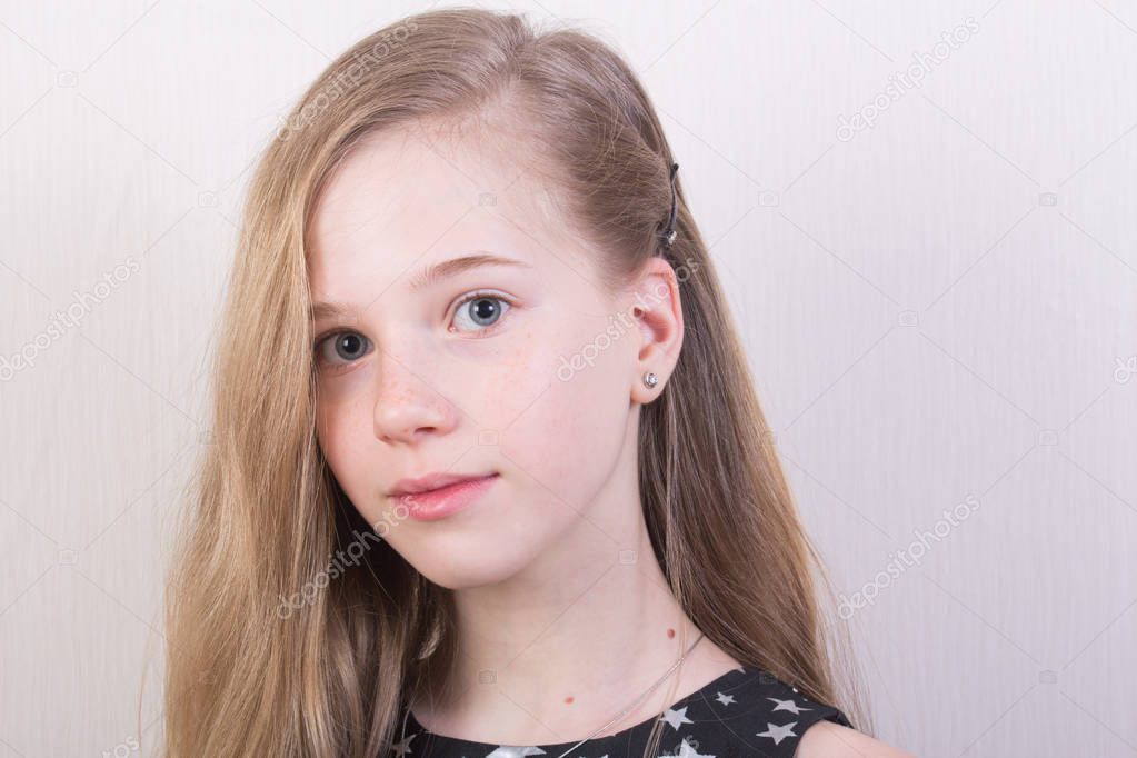 Portrait of a young girl with light brown hair in a black dress with silver stars
