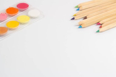 Beyaz arka planda renkli kalemler ve pastel renkler