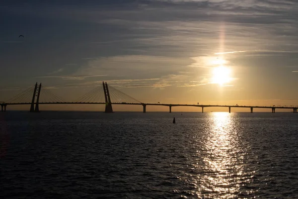 Long cable-stayed bridge on the background of a beautiful sunset on the sea — Stock Photo, Image