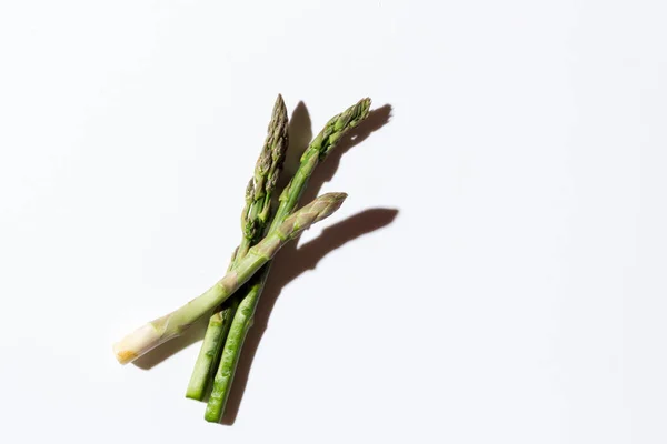 Gri arka planda gri bir iple bağlanmış yeşil taze kuşkonmaz. Yüksek kalite fotoğraf