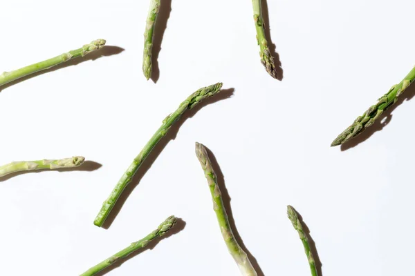 Gri arka planda gri bir iple bağlanmış yeşil taze kuşkonmaz. Yüksek kalite fotoğraf