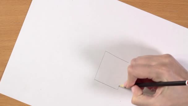 Main féminine dessine une maison avec un crayon