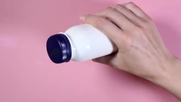 Female hand twists a white bottle in hand — Stock Video