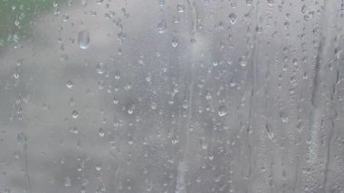 Su damlaları gri bardaktan aşağı akıyor.