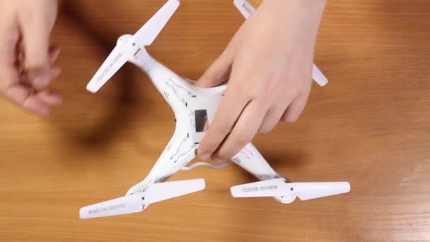 Las manos masculinas tuercen un primer plano de un dron blanco. Vista superior — Vídeos de Stock