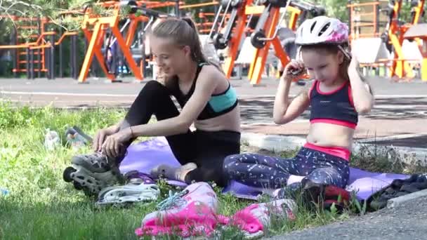 Twee Meisjes Maken Zich Klaar Rolschaatsen Zetten Een Helm Speelplaats — Stockvideo