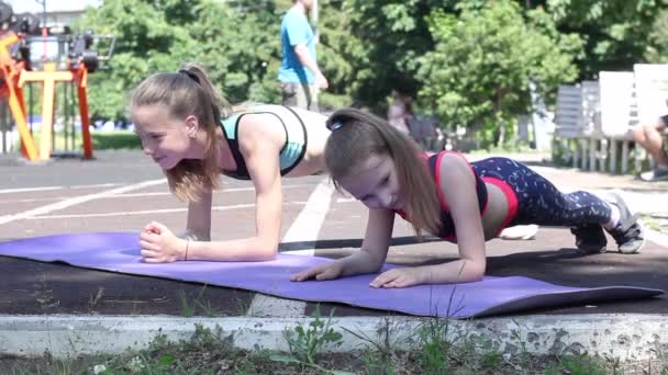 Duas Atletas Sportswear Fazendo Exercício Prancha Campo Esportes Dia Ensolarado — Vídeo de Stock