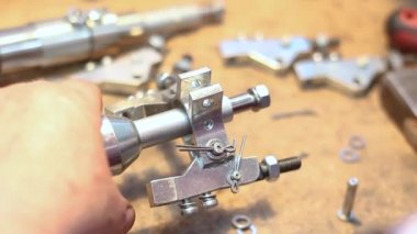 Fabrikadaki işçilerin elleri küçük parçalardan metal parçaları birleştiriyor. Yüksek kaliteli FullHD görüntüler