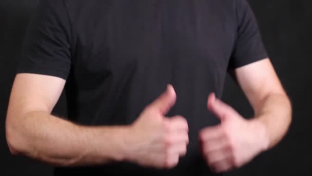 Manos masculinas caucásicas en una camiseta negra de manga corta, tirando de un puño — Vídeos de Stock