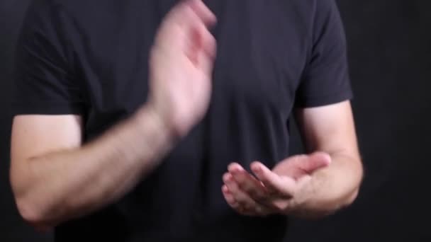 Кавказькі чоловічі руки в чорній короткій футболці, плечі на долоні — стокове відео