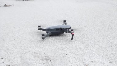 Bulutlu bir günde gri bir dron yerden havalanıyor.