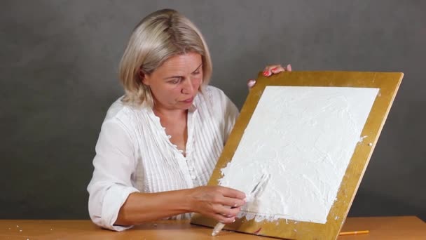 Middleaged caucasian woman demonstrates the process of making decorative plaster — Stock Video