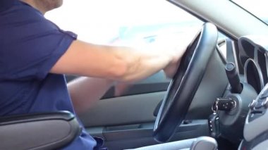 Mavi kısa kollu beyaz adam bir araba kullanıyor. Yakından.