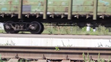 Güneşli bir yaz gününde istasyondan geçen yük treni kapanır.