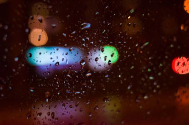 Arka plan. Damla bokeh renk daireler ile gece camının