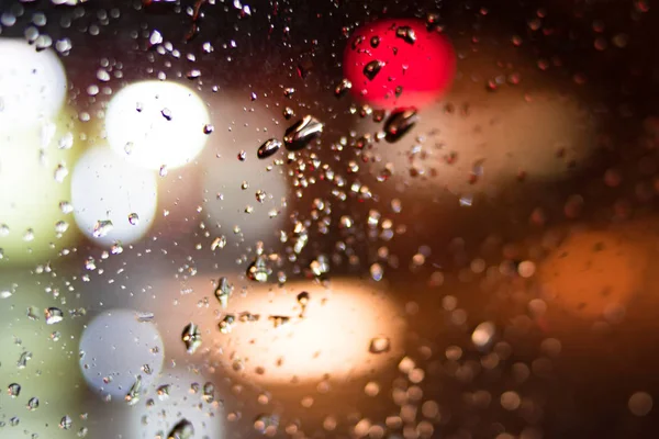 Arka plan. Damla bokeh renk daireler ile gece camının