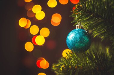 Mavi Noel top yuvarlak garland ışıklar arka plan çok renkli bokeh ile Ladin Noel ağacı üzerinde