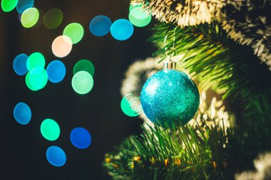 Mavi Noel top yuvarlak garland ışıklar arka plan çok renkli bokeh ile Ladin Noel ağacı üzerinde