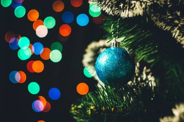 Mavi Noel top yuvarlak garland ışıklar arka plan çok renkli bokeh ile Ladin Noel ağacı üzerinde