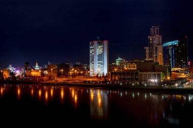 Güzel bir gece cityscape görünümünü Yekaterinburg ve Iset Nehri ışık yansımaları ile buz üstünde