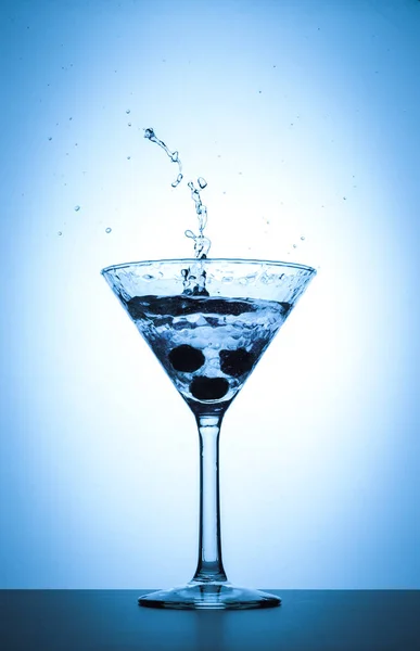 分離した白と青のグラデーションの背景にカクテルのマティーニ グラス スプラッシュ — ストック写真