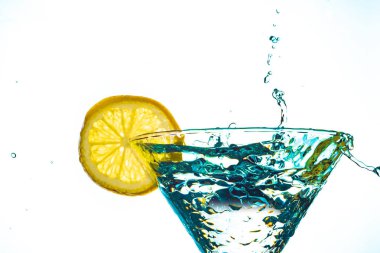 Mavi kokteyl su içki sıçrama limon ile cam izole beyaz arka plan üzerinde
