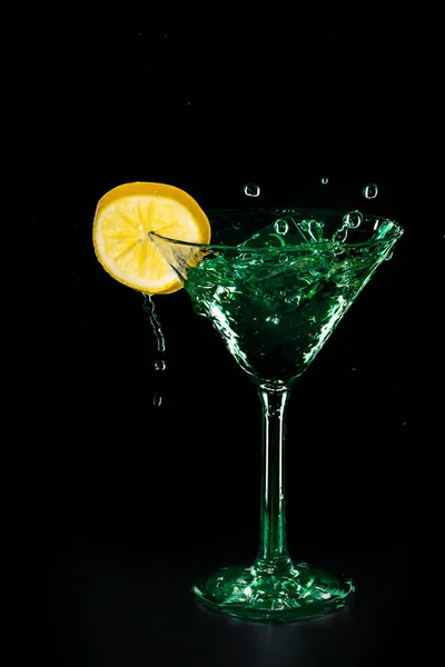 Yeşil Kokteyl su içki sıçrama limon ile cam izole siyah arka plan üzerine