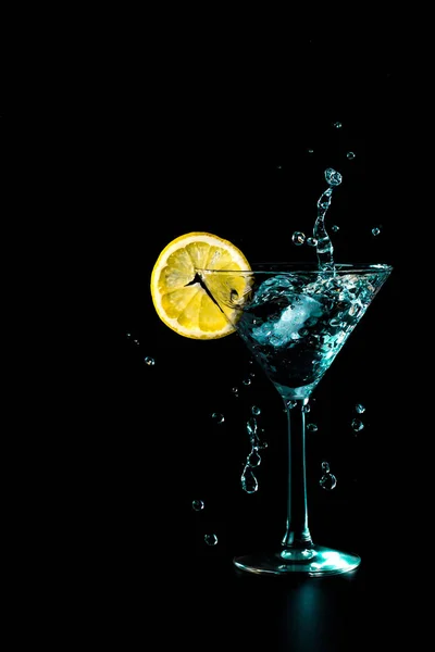 黒い背景に分離された青いカクテル水ドリンク スプラッシュ レモン グラス — ストック写真
