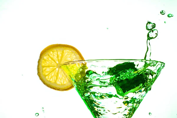 Kokteyl su içki sıçrama limon ile cam izole beyaz arka plan üzerinde