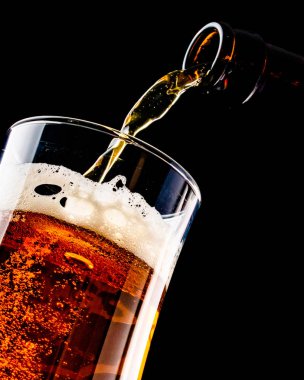 Bira şişe siyah arka plan üzerine izole bir bardak içine dökme