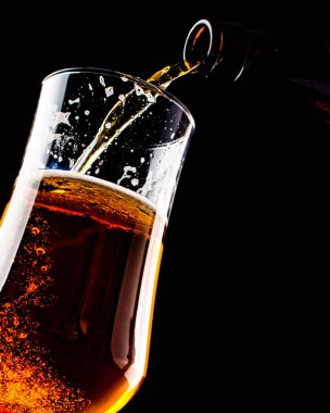 Bira şişe siyah arka plan üzerine izole bir bardak içine dökme