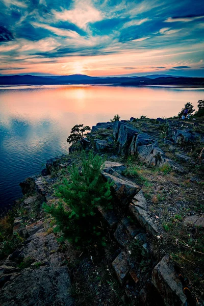 Красивий пейзаж заходу сонця на гірському озері з сонцем, що ховається за горами на протилежному березі — стокове фото