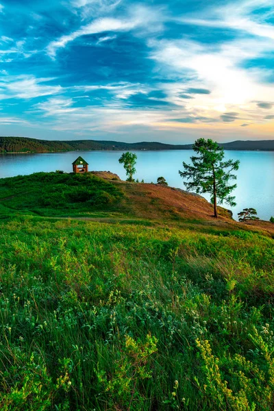 Чудовий краєвид на гірський озеро Турґояк, Росія з хмарним небом і літній будиночок на пагорбі влітку — стокове фото