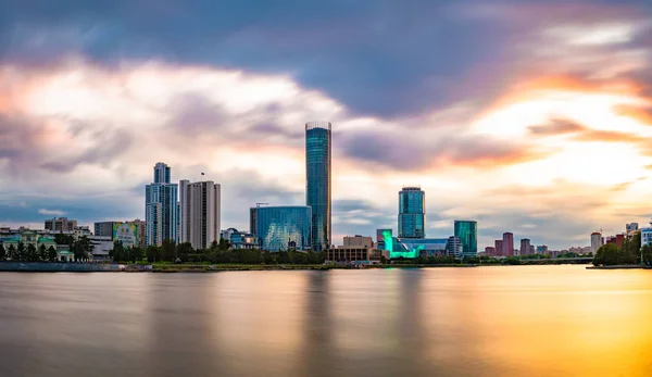 Wunderschönes panorama der stadt yekaterinburg, russland bei untergang. Wolkenkratzer spiegeln sich im Wasser des iset River — Stockfoto