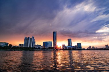 Şehir göletgüzel bulutlu gün batımı. Yekaterinburg Cityscape, Rusya skyscrappers suya yansıtan