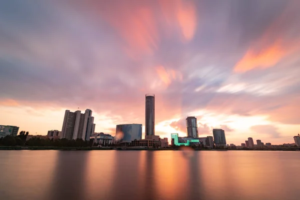 Piękny pochmurny zachód słońca w mieście staw. Długa ekspozycja gród Jekaterynburgu, Rosja z skyscrappers odzwierciedlające w wodzie — Zdjęcie stockowe